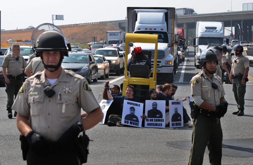 Warehouse workers block truck traffic, choking the supply chain to advocate for labor rights, 2009.